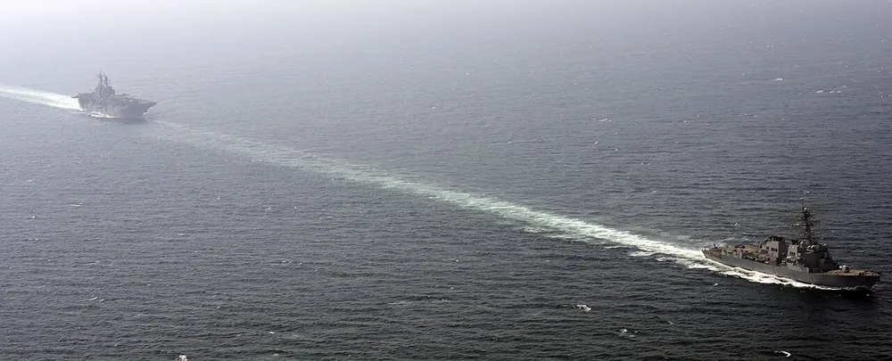 The guided-missile destroyer USS Roosevelt (DDG 80) escorts the amphibious assault ship USS Bataan (LHD 5) through the Strait of Hormuz on 22 September 2014.