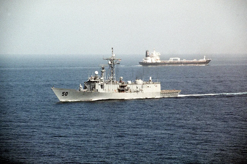 The guided-missile frigate USS Taylor (FFG-50) passes an oil tanker after transiting the Strait of Hormuz during Operation Desert Shield.