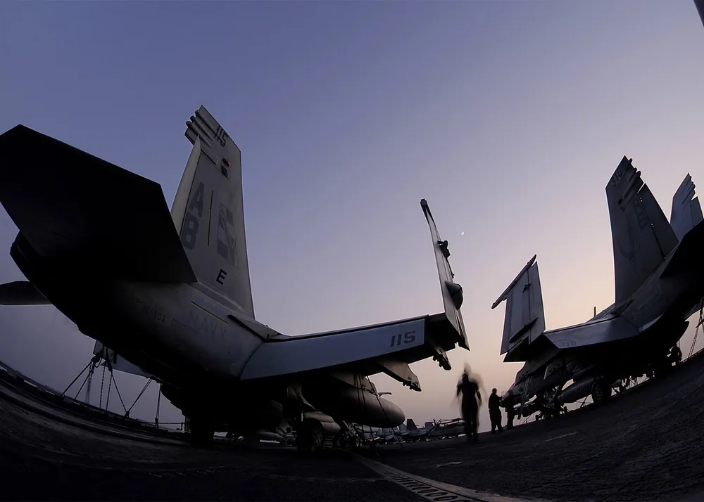Flight-deck crew secure aircraft as the aircraft carrier USS Enterprise (CVN 65) transits the Strait of Hormuz on 29 June 2006.