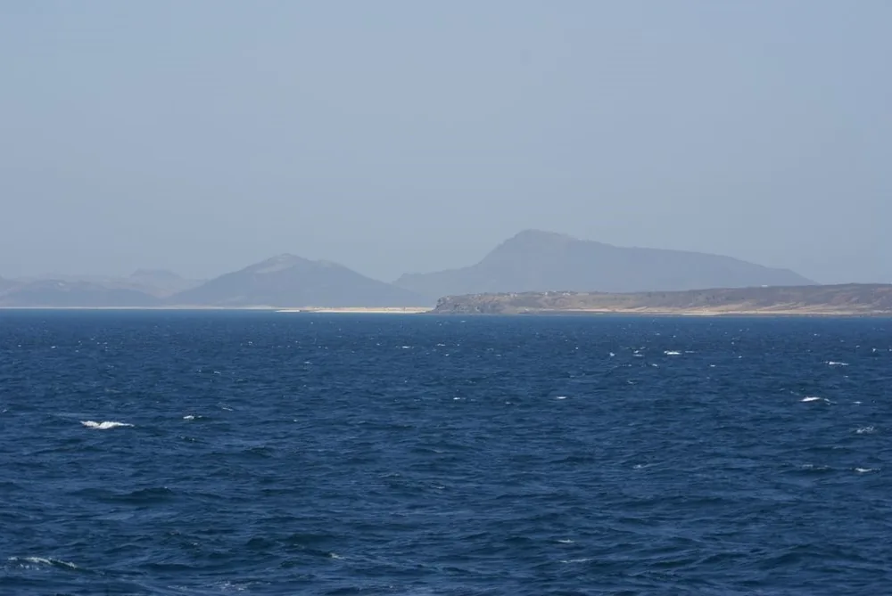 The northern part of Perim (Mayyun) Island in the Bab al-Mandeb Strait, with coastal Yemen beyond.
