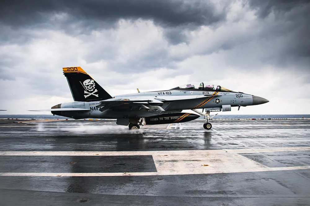 An F/A-18F Super Hornet of VFA-103 on the wet flight deck of USS George Washington (CVN-73). Photo: U.S. Navy, public domain.