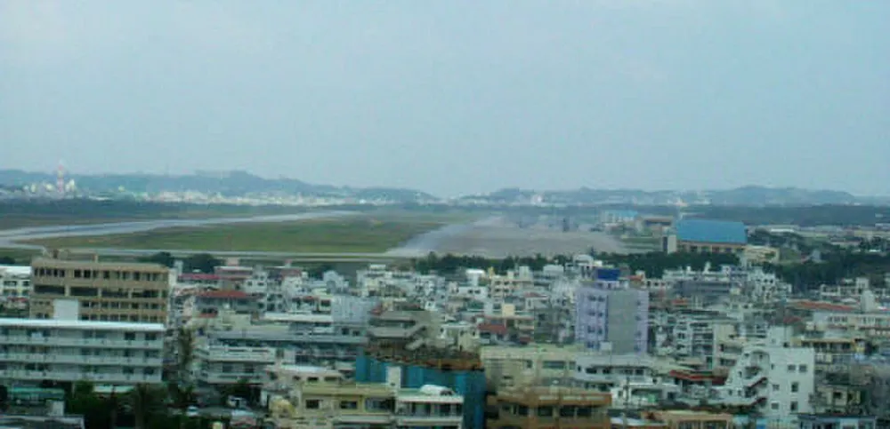 MCAS Futenma airfield beside dense Ginowan neighbourhoods in Okinawa. Photo: Liandrei / Wikimedia Commons, public domain.