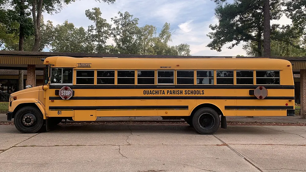 A yellow American school bus parked at an elementary school. Photo: Ktkvtsh / Wikimedia Commons, CC BY-SA 4.0.